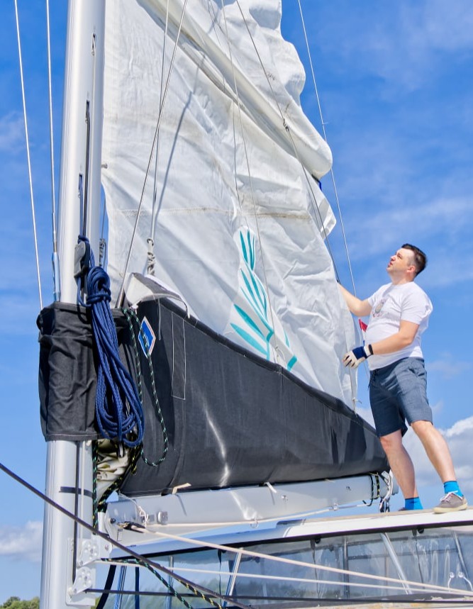 Capità aixecant la vela d’un veler amb funda protectora